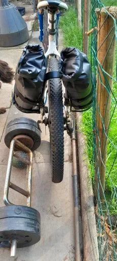 Photo client : deux sacoches étanches 5 L sur le porte-bagages arrière d'un vélo blanc, vue de dos
