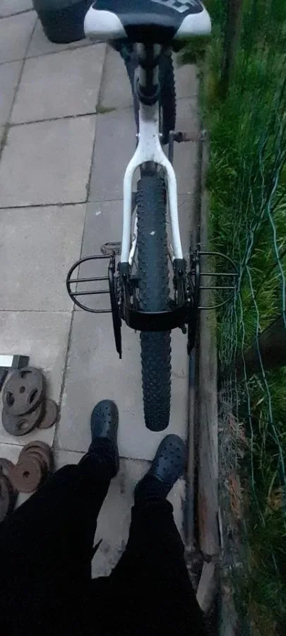 Photo client : porte-bagages arrière vu de haut derrière la selle d'un vélo blanc