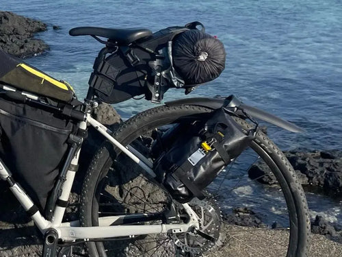 Photo client : vélo chargé en bord de mer avec le porte-bagages arrière et ses sacoches