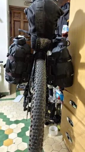 Photo client : VTT vu de l'arrière avec le porte-bagages et une sacoche de chaque côté de la roue