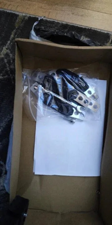 Photo client : platines à sangle et visserie du porte-bagages réglable dans leur sachet
