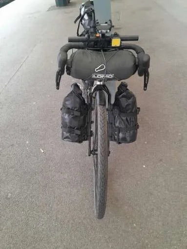 Vélo de bikepacking équipé de deux sacoches de fourche étanches 5 L noires, vu de face