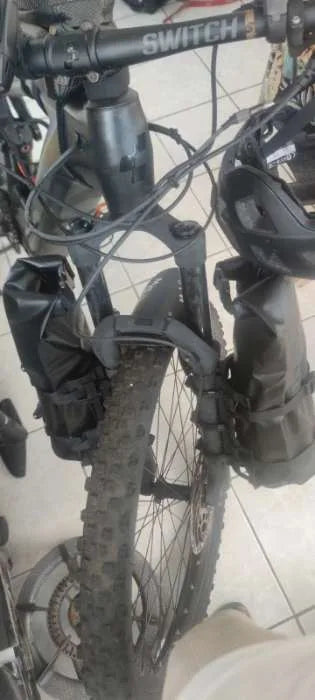 Deux sacoches de fourche vélo 5 L foncées montées de chaque côté de la fourche d'un VTT