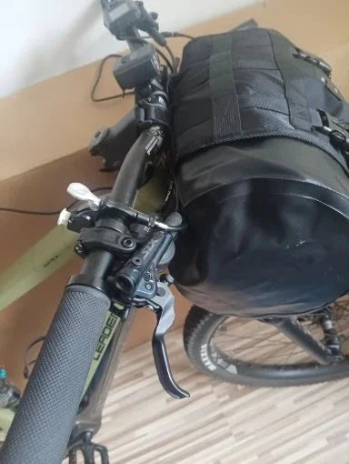 Gros plan sur la sacoche de guidon étanche fixée au cintre, à côté du levier de frein