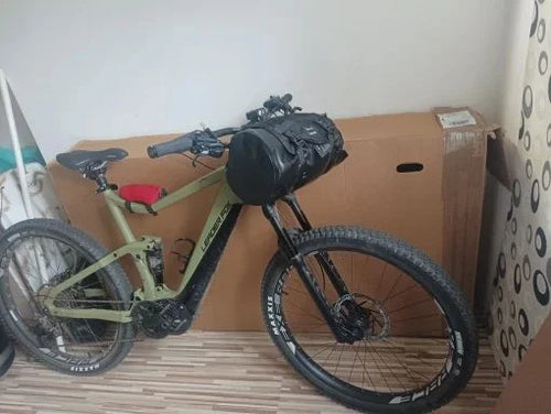 VTT électrique vert équipé de la sacoche de guidon étanche noire, vue de trois quarts