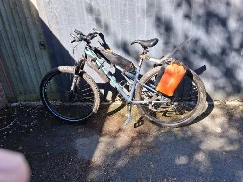 Sacoche vélo orange 10 L fixée sur le porte-bagages arrière d'un VTT