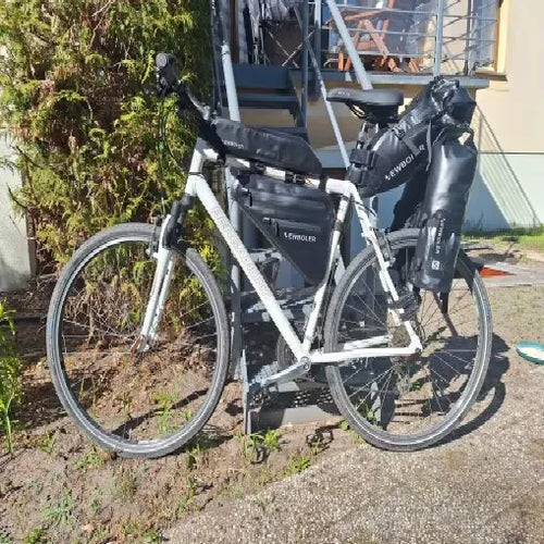 Photo client : vélo blanc entier équipé des sacoches étanches 5 L à l'arrière, garé dans un jardin