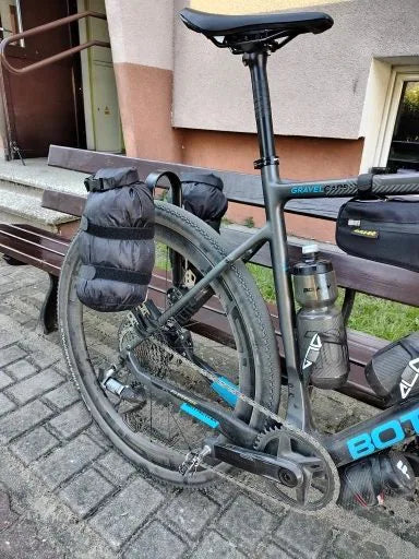 Photo client : vélo gravel vu de côté, sacoches étanches montées sur le porte-bagages arrière