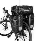 Vélo noir équipé du kit 3 sacoches de porte-bagage arrière noires, vu de trois quarts sur fond blanc