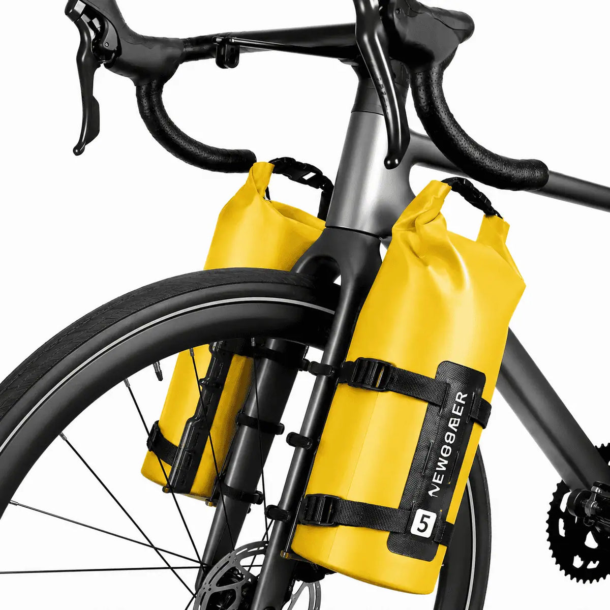 Deux sacoches cylindriques jaunes 5L fixees sur les fourches avant d un velo de route gris vue rapprochee.