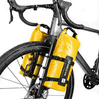 Deux sacoches cylindriques jaunes fixees sur les fourches d un velo de route sous la pluie vue en contre plongee.