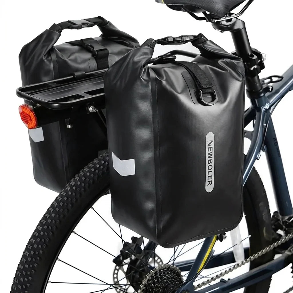 Deux sacoches imperméables noires installees sur le porte-bagage arriere d un velo, vues de profil.