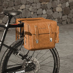 Double sacoche caramel en cuir fixee sur le porte-bagage arriere d'un VTT.