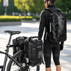 Cycliste debout près de son vélo chargé de 2 sacoches latérales, la sacoche de dessus portée en sac à dos