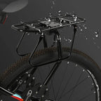 Porte-bagage arrière en aluminium noir sous des gouttes d'eau, monté sur la roue arrière d'un VTT