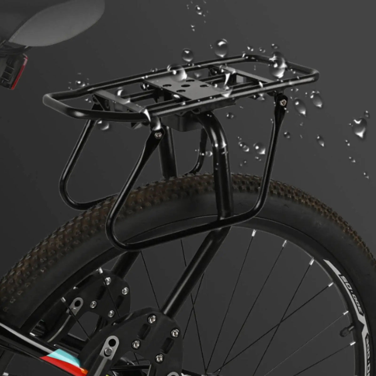 Porte-bagage arrière en aluminium noir sous des gouttes d'eau, monté sur la roue arrière d'un VTT