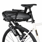 Sacoche noire montée sur le porte-bagages d'un vélo blanc, vue de côté