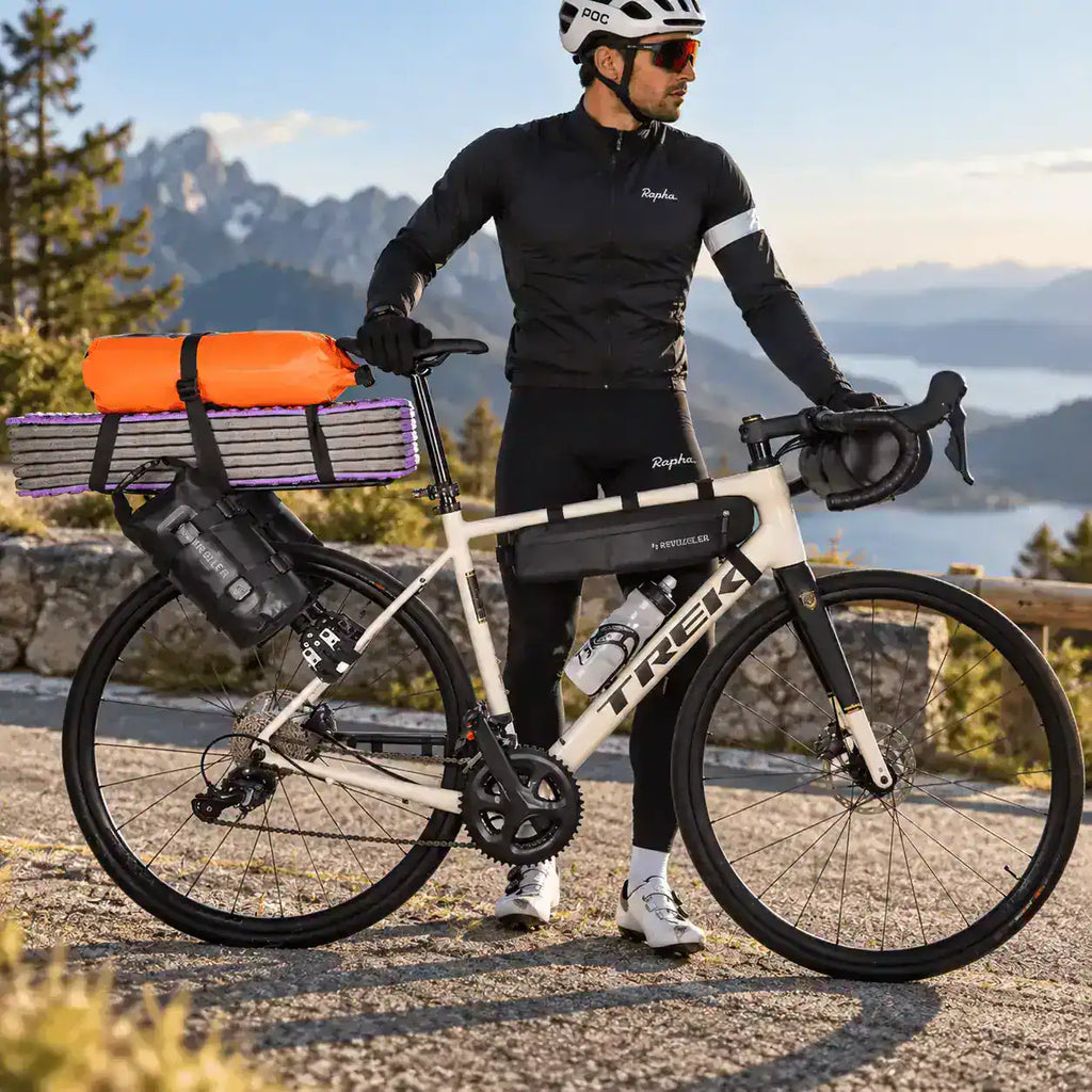 Cycliste en sortie de montagne, sacoche orange sanglée sur le porte-bagages arrière