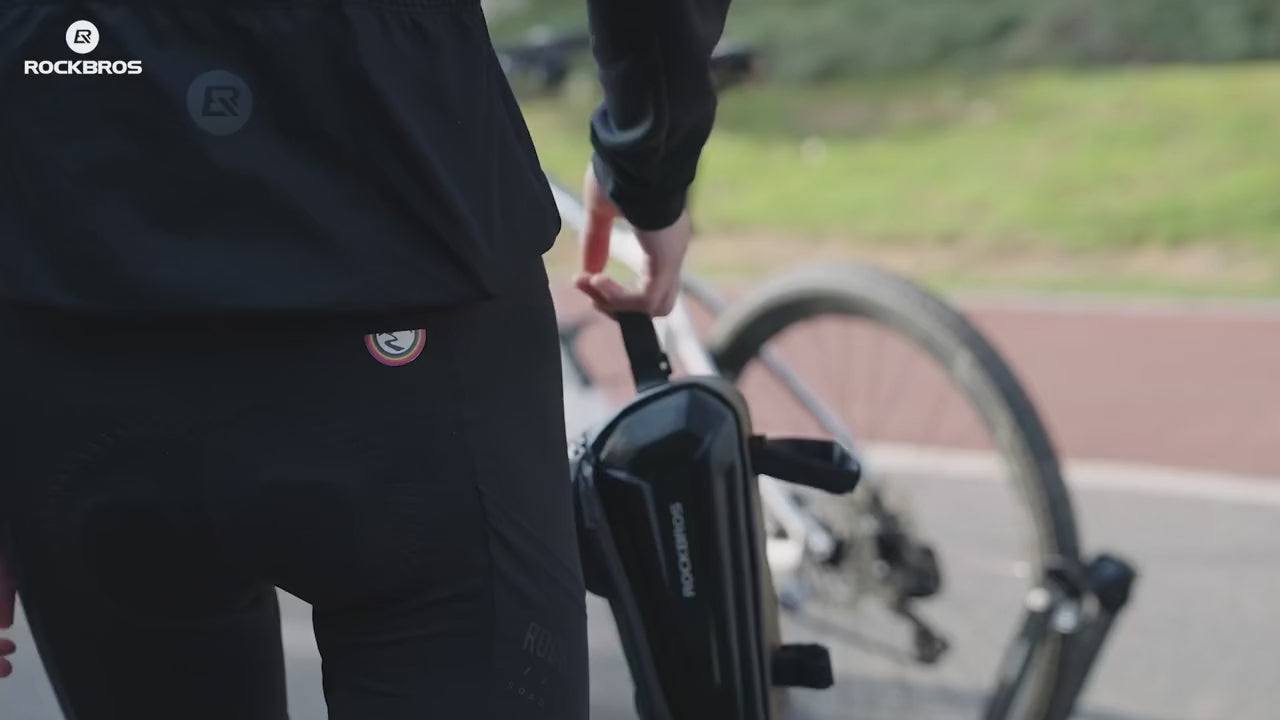 Cycliste roulant avec la sacoche de cadre fixée sur le tube supérieur du vélo