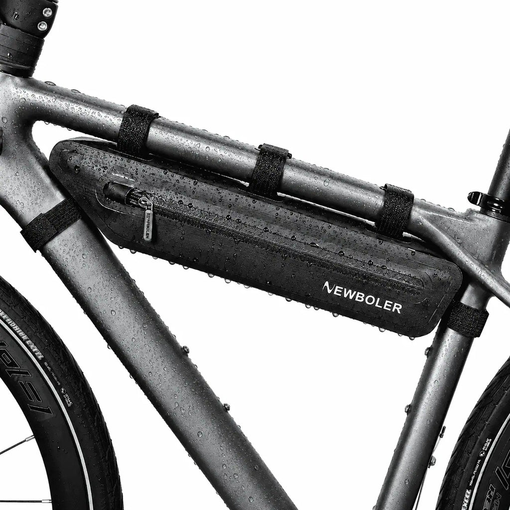 Sacoche triangulaire noire installee sur le cadre d'un velo, vue rapprochee avec fixations sangles.