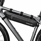 Sacoche triangulaire noire installee sur le cadre d'un velo, vue rapprochee avec fixations sangles.
