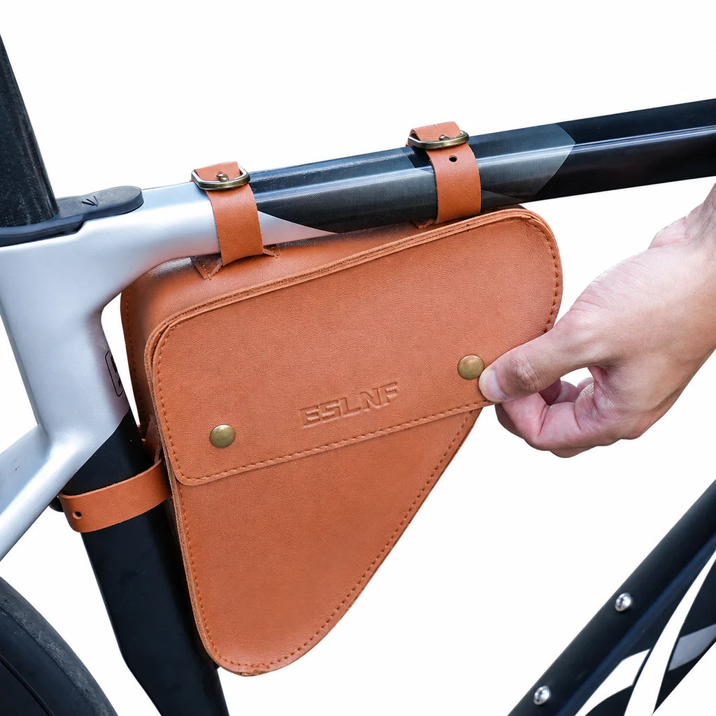 Détail d'une sacoche de cadre vélo triangulaire en cuir orange avec ouverture du bouton-pression