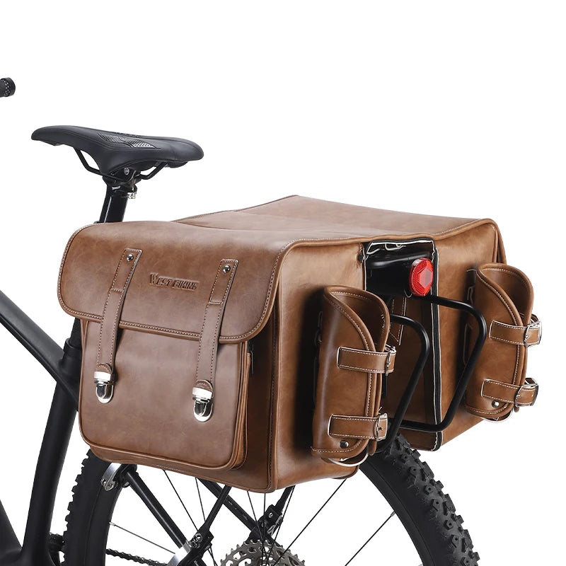 Sacoche de velo en cuir caramel avec feu rouge fixee sur le porte-bagage arriere d'un VTT.