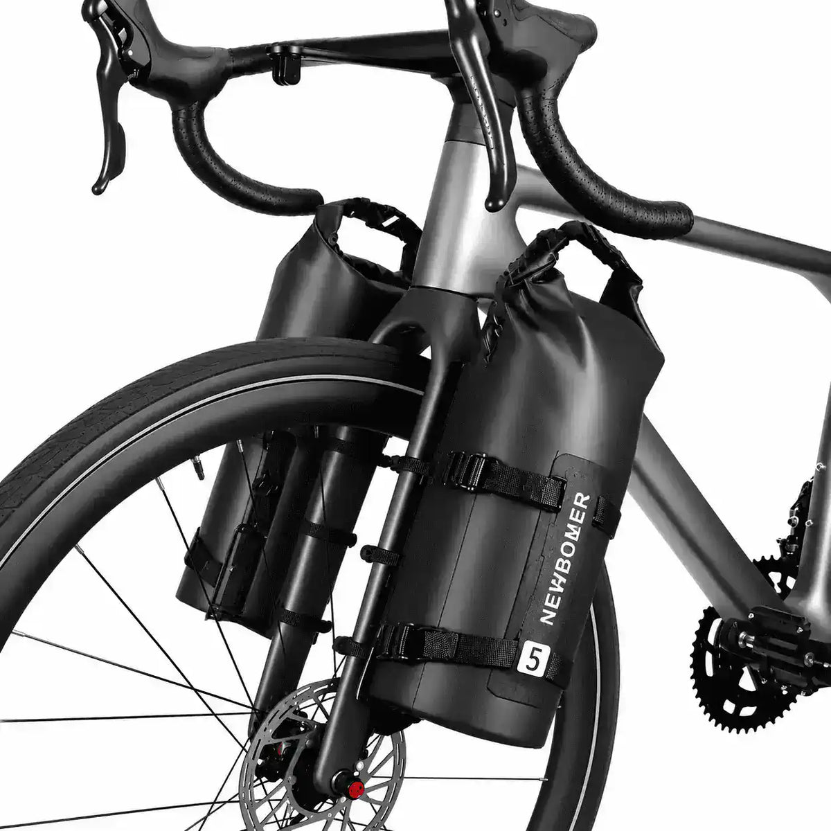 Deux sacoches cylindriques noires fixées sur la fourche d'un vélo de route gris vue de côté