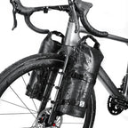 Sacoche cylindrique noire fixée sur la fourche d'un vélo de route sous une forte pluie