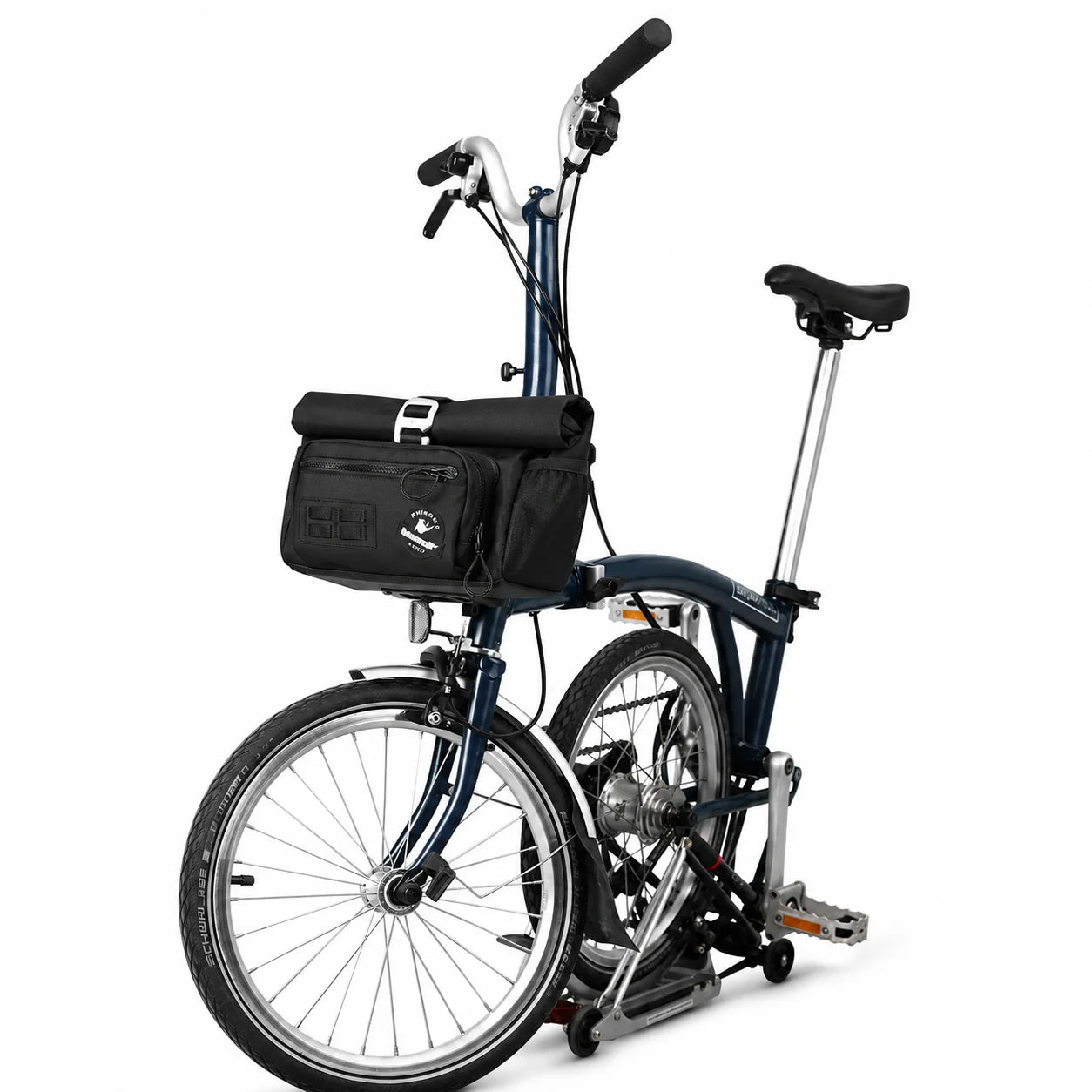 Sacoche de guidon noire fixée à l'avant d'un vélo pliant bleu marine, vue de côté sur fond blanc.