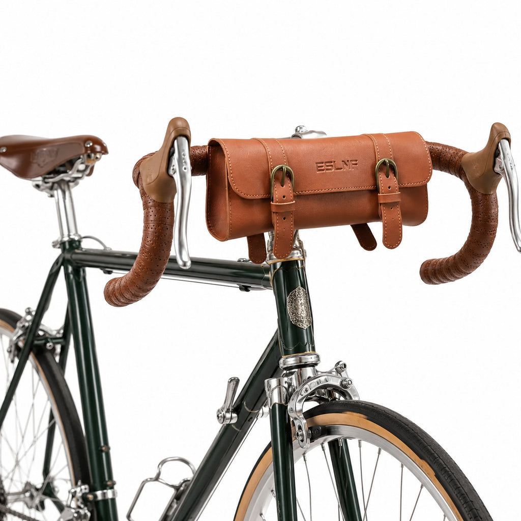 Sacoche de guidon vélo en cuir marron vintage fixée sur un vélo de route vert