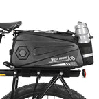 Sacoche de porte bagage arriere noire avec porte bidon integre montee sur un velo a gros pneus.