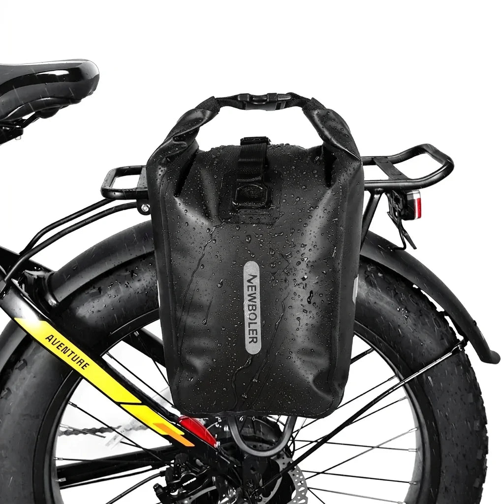 Sacoche imperméable noire avec gouttes d eau, installee sur le porte-bagage arriere d un velo fat bike.