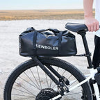 Grande sacoche noire installee sur le porte-bagage arriere d un velo tout terrain blanc dans un paysage aride