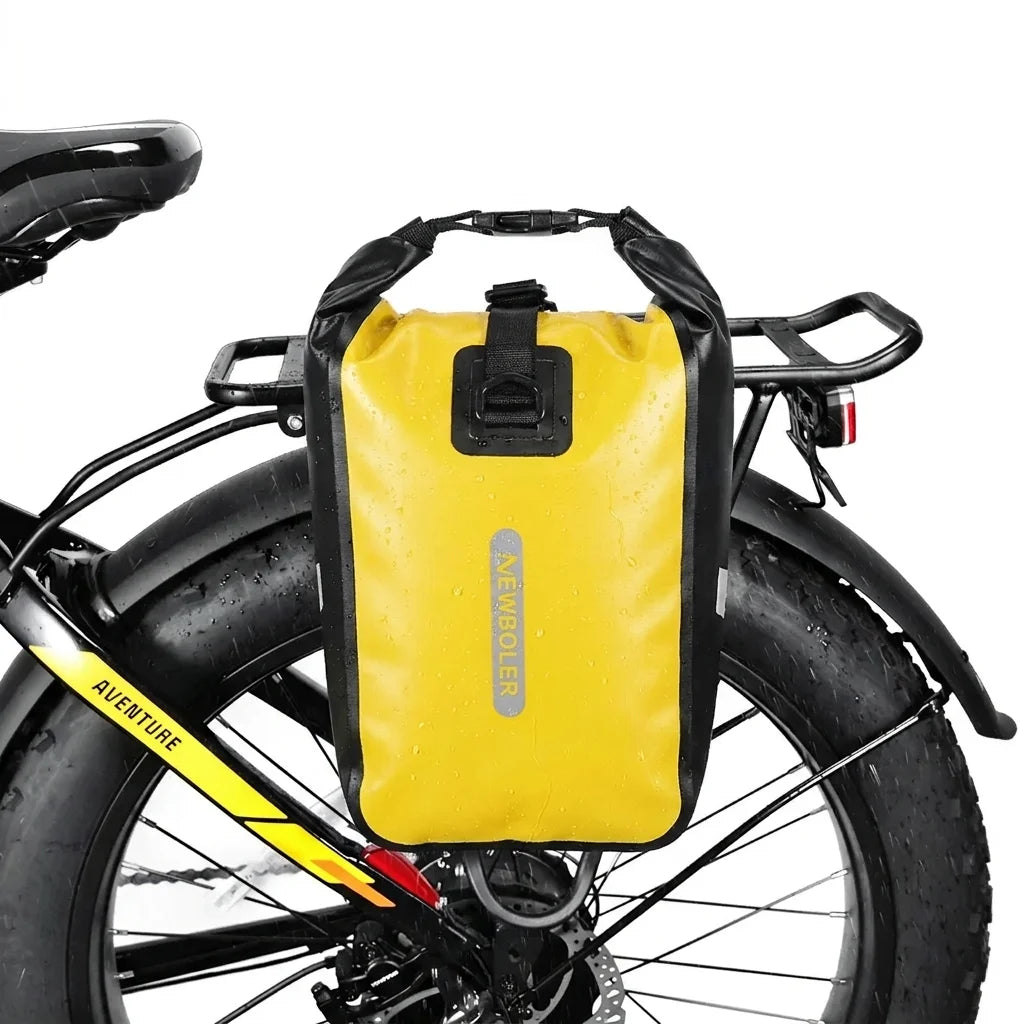 Sacoche jaune etanche fixee sur le porte-bagage arriere d un velo a gros pneus, vue de cote.