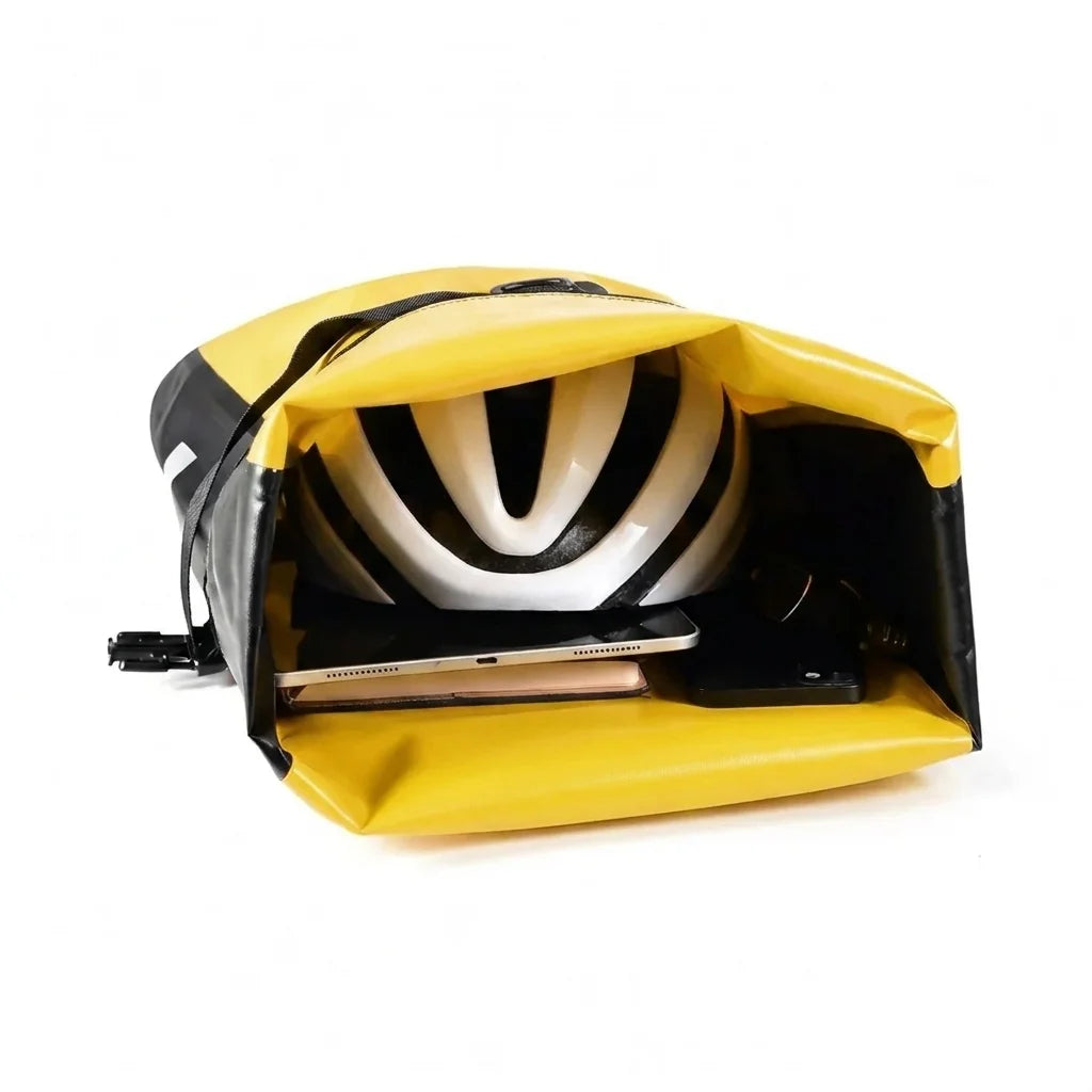 Sacoche de porte-bagage jaune et noire ouverte contenant un casque de velo blanc et un ordinateur portable.