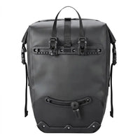 Sacoche de porte-bagage noire etanche vue de face, avec fermeture roll-top et poignee de transport, presentee sur fond blanc.