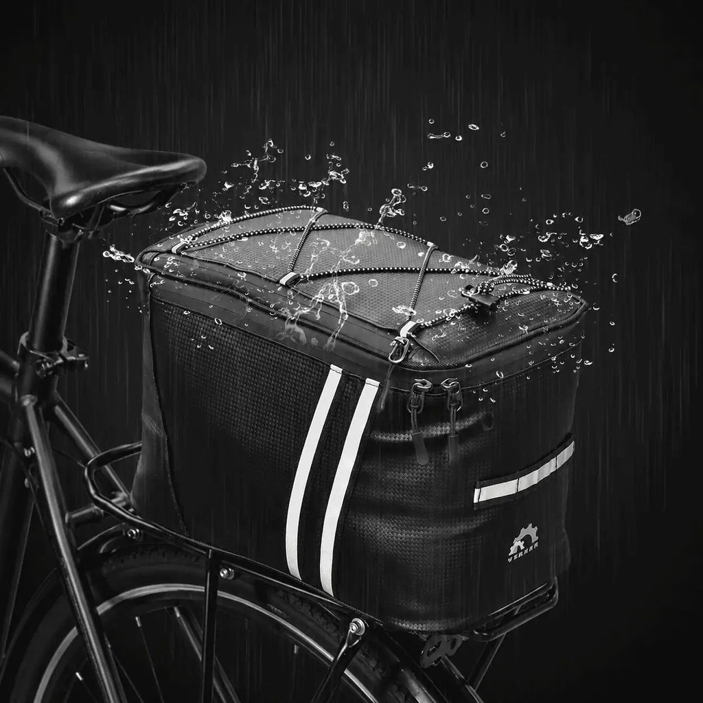 Sacoche de porte-bagage vélo noire installée sur un vélo sous la pluie, avec des éclaboussures d'eau illustrant son imperméabilité.