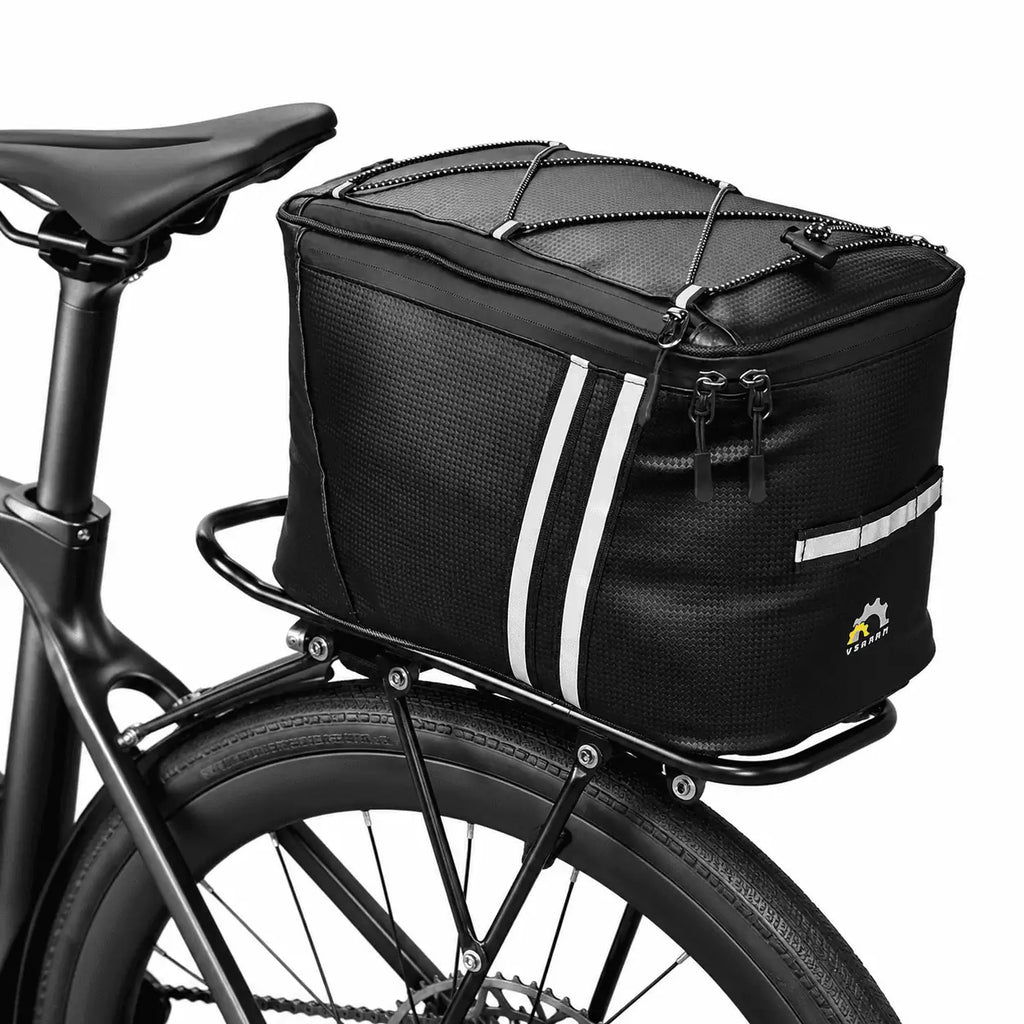 Sacoche de porte-bagage vélo noire vue de côté, installée sur un porte-bagage arrière métallique avec bandes réfléchissantes.