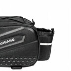 Gros plan d'une sacoche de porte-bagage vélo noire avec poche latérale à maillage et bande réfléchissante