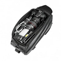 Sacoche de porte-bagage vélo noire ouverte vue de dessus avec un appareil photo et accessoires