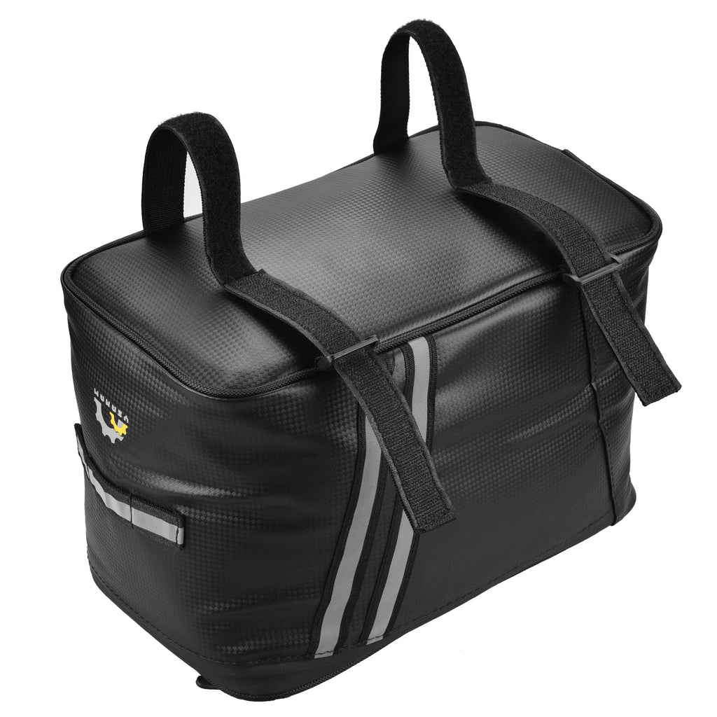 Sacoche de porte-bagage vélo noire vue de trois quarts, avec deux poignées de transport sur le dessus et bande réfléchissante grise.