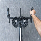 Cycliste tenant le guidon d'un vélo de route sous la pluie avec deux sacoches de potence noires