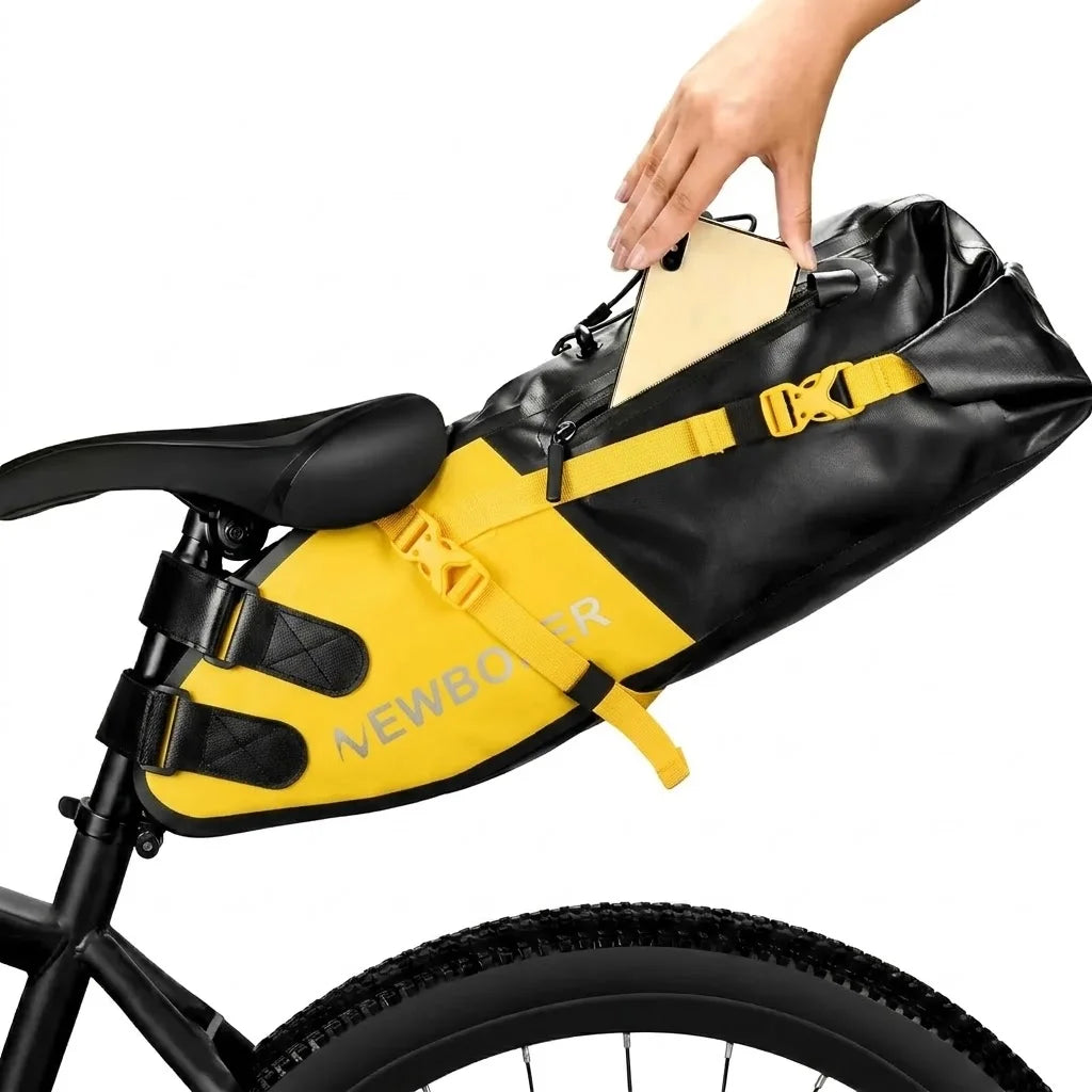 Main glissant un téléphone dans la poche d'une sacoche de selle jaune et noire fixée sur un vélo.