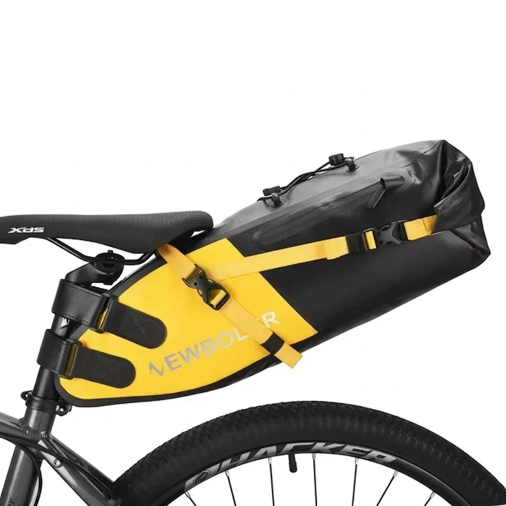 Vue rapprochée d'une sacoche de selle jaune et noire avec sangles de fixation, montée sur un vélo gravel gris.