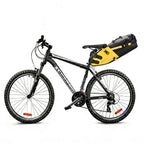 Sacoche de selle jaune et noire fixée sous la selle d'un VTT noir, vue d'ensemble du vélo sur fond blanc.