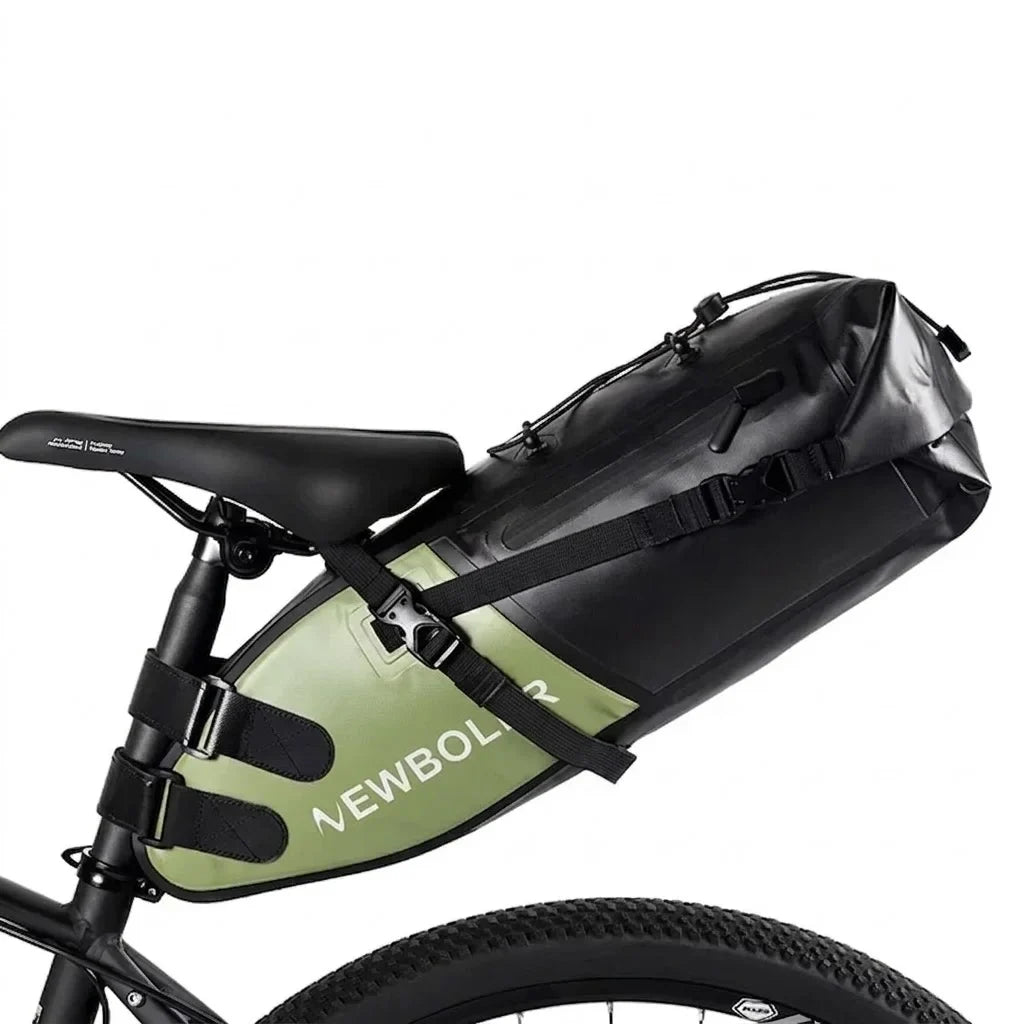 Sacoche de selle noire volumineuse fixée sous la selle d'un vélo gravel, avec une sacoche de cadre verte visible en dessous.