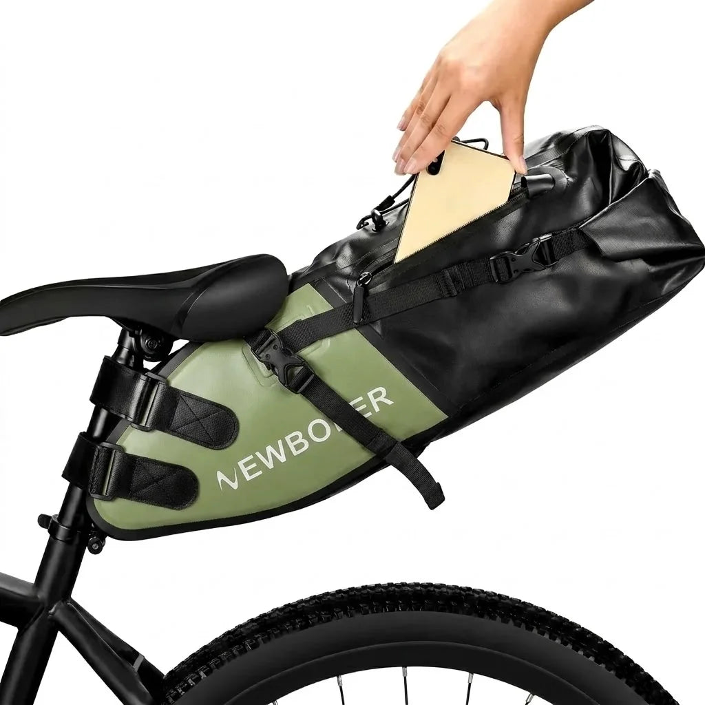 Main glissant un téléphone dans la poche d'une sacoche de selle noire et verte fixée sur un vélo.