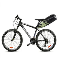 Sacoche de selle noire et verte installée sous la selle d'un VTT noir, vue d'ensemble du vélo sur fond blanc.