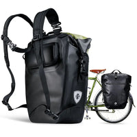 Sacoche noire 27L aCycliste en tenue portant sacoche noire en sac à dos et sacoche jaune porte-bagagesvec brételles réglables, vue backpack et porte-bagages sur vélo